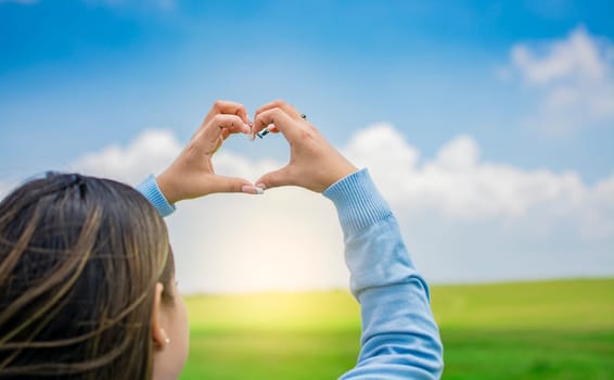 Hands together in a heart shape, woman's hands together in a heart shape, hands making a heart shape