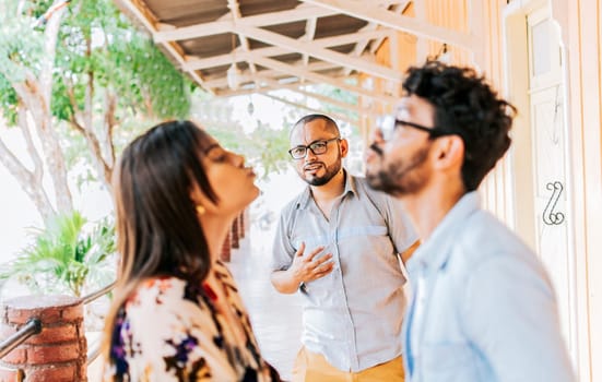Man looking at his cheating girlfriend kissing another woman outdoors, Man discovering his cheating girlfriend kissing another man in the street, Boyfriend discovering his girlfriend's infidelity outdoors