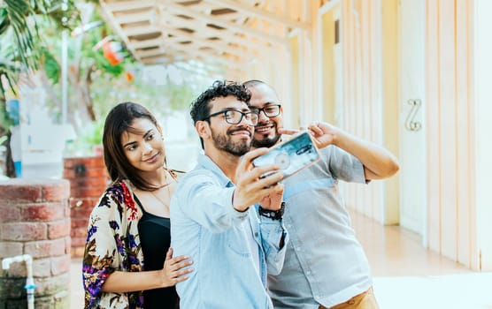 Three friends taking a selfie outside, Three smiling friends taking a selfie on the street. Front view of three cheerful friends taking a selfie on the street. Friends selfie concept.