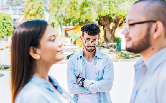 Sad man seeing his girlfriend cheating with his friend outdoors, Sad boyfriend seeing his girlfriend with another one outdoors. Man watching his girlfriend cheating with another man