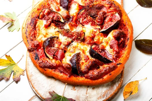 Appetizing pizza with bacon and autumn fruit, figs.