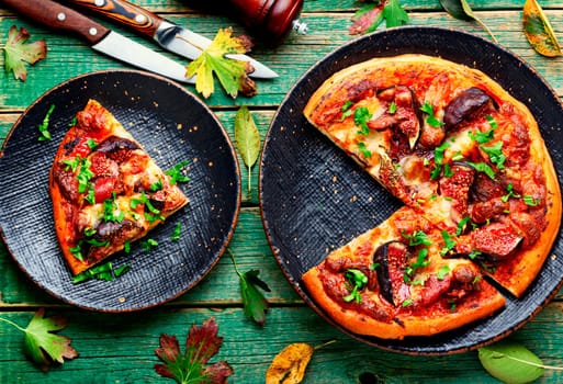 Appetizing pizza with bacon and autumn fruit, figs.