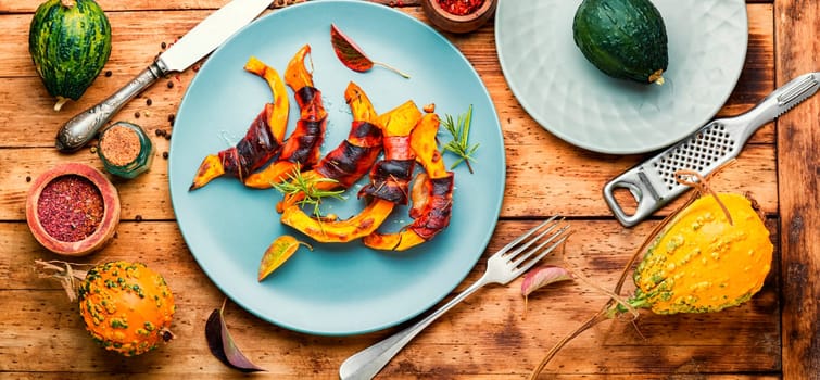Autumn baked pumpkin pieces wrapped in bacon. Thanksgiving Day