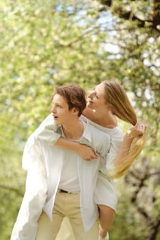 Young couple having fun outdoor in blooming park