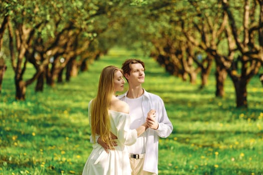 Cute couple in love hug each other while standing in the park