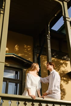 Young couple in love standing on balcony and looking at each other