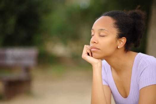 Black woman relaxing mind sitting alone in a park