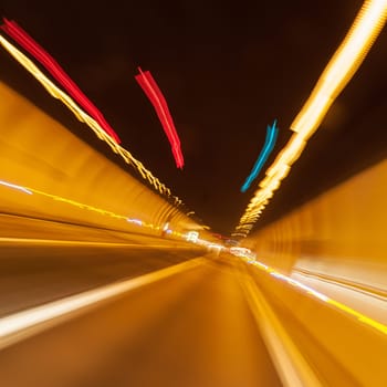 Abstract motion in tunnel made by lights and moving car. Real photography