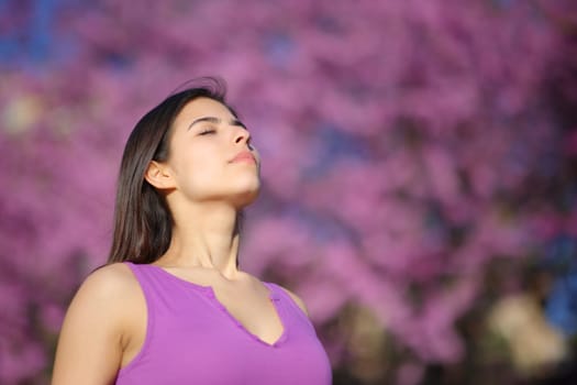 Relaxed woman breathing fresh air on violet in a park