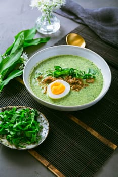 Wild garlic soup, bear leek soup (ramson soup) with boiled egg