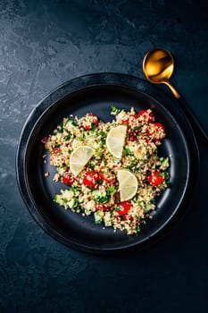 Tabbouleh salad, traditional middle eastern and arab dish. Levantine vegetarian salad with parsley, mint, bulgur, tomato and cucumber