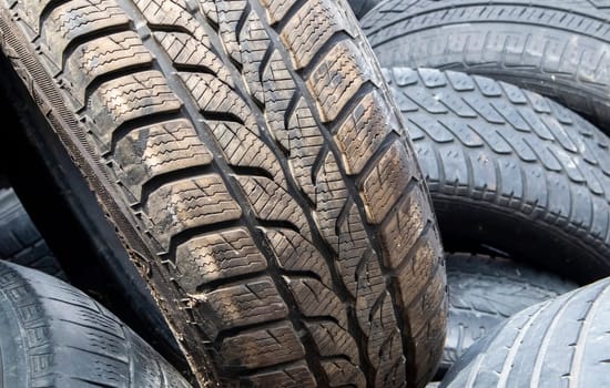 Worn wheels for recycling. Plant for burning tire dumps. Mountain of old tires. Used wheel junkyard. Pile of old tires and wheels for rubber recycling. Recycling concept