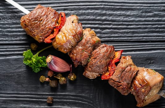 Raw Shish kebab from mince lamb and beef meat, turkish adana kebab on Skewers. Black background. Top view. Copy space.