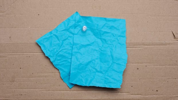 Blue sheet with tear-off edges for writing an ad on a brown background, copy space