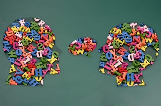 Two silhouettes of human heads with colorful letters, concept of conversation, intellectual discussion