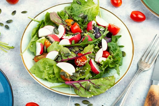 Easy salad with radish, greens, tomato and sesame seeds. Healthy diet food
