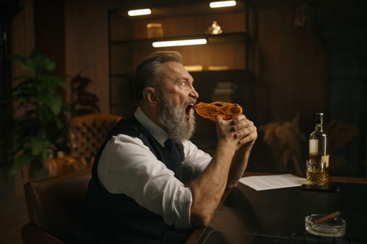 Funky elderly man trying to shoot himself with toy gun while sitting at desk table in home office. Business problems, bad contract, bankruptcy concept