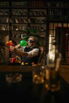 Selective focus of rich elegant senior businessman playing toys at home office. Elderly mature male character wearing elegant suit and pilot goggles having fun and rest after hard work day
