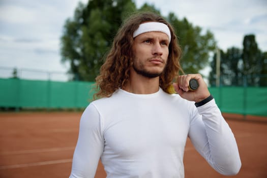 Portrait of male tennis player wearing trendy outfit ready for morning workout on outdoor court