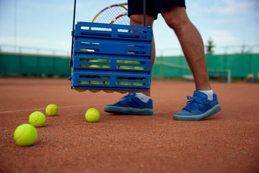 Closeup view of tennis player picking up scattered balls on field after game training. Professional occupation or hobby recreation concept