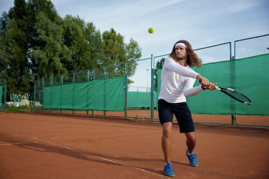 Professional tennis player with racket playing game on outside hard court. Outdoor sport activity