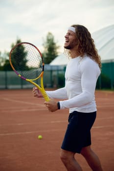 Emotional professional tennis player celebrating win clenching fists. Professional sportsman showing winner facial expression feeling excitement after win in highly tensioned game