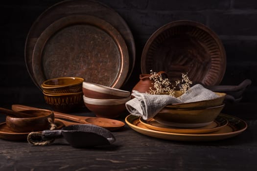 Set of kitchen ceramic and wooden tableware a table. Eco style home still life. Vintage style