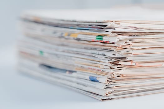 Pile of newspapers on table. Folded and stacked journals.