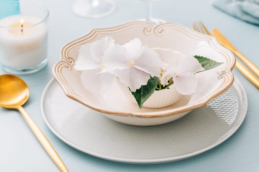 Spring shabby chic table setting, plate decorated with flowers
