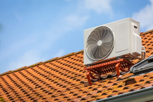 Dual inverter, combination of air conditioner compressor and heating pump, installed on a roof of family house.