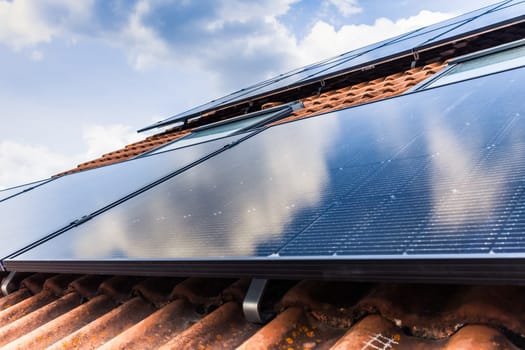 Photovoltaic panels on the roof of family house, solar panels. Environment and technology concepts.