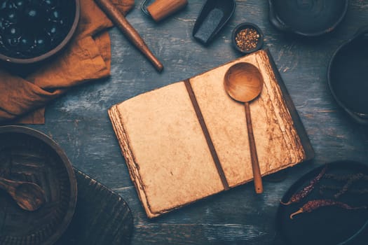Empty menu or cookbook and kitchen utensils on wooden table, vintage style