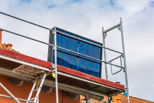 Installing solar panels on a roof. Solar panels on roof. Workers installing solar cells.
