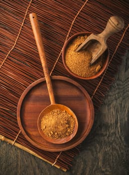 Organic coconut plam sugar in wooden scoop and bowl