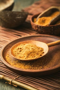 Organic coconut plam sugar in wooden scoop and bowl