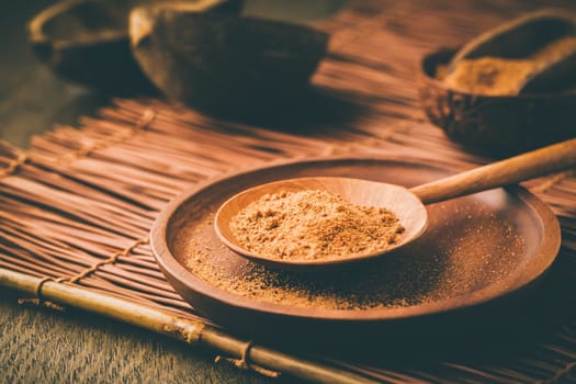 Organic coconut plam sugar in wooden scoop and bowl