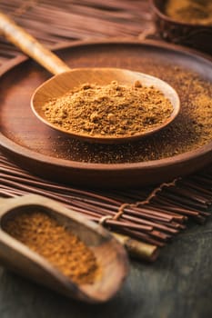 Organic coconut plam sugar in wooden scoop and bowl