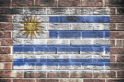 A Uruguay flag on a brick wall background blue white stripes Sun of May