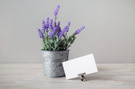 Photo of blank business card and tin bucket with artificial lavender.