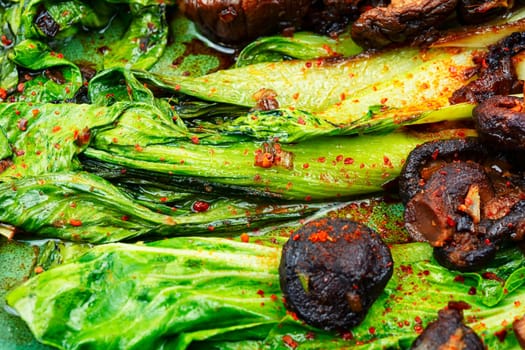 Chinese fried Pak Choi with shitake mushrooms and chopstick. Asian vegan food