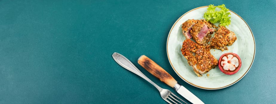 Steak of baked tuna in a nut panic with a mangosteens. Copy space, long banner.