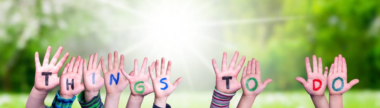 Children Hands Building Colorful English Word Things To Do. Sunny Green Grass Meadow As Background.