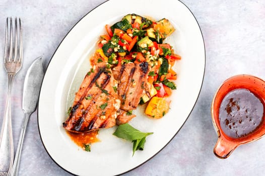 Delicious grilled tuna steak with baked vegetables on a plate. Barbecue fish grilled