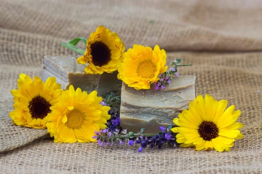 Natural handmade soap with calendula, lavender and herbs on rustic wooden background