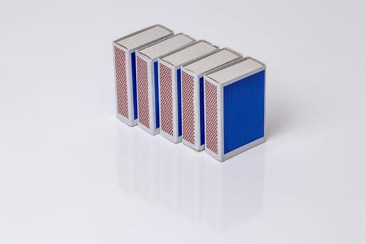 Closeup of five matchboxes on a bright background with copyspace. Savety matches in boxes. Macro.