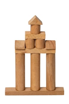 Wooden isolated house. Wooden toy castle constructed of cubes, cylinders, triangles and other shapes made of beech wood. Wooden toy blocks. Macro.