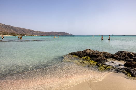 Elafonisi, Crete, Greece - Sept 19, 2021: People relaxing on the famous pink coral beach of Elafonisi on Crete, Mediterannean sea, Greece