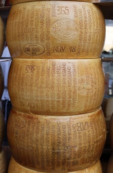 Cremona, Italy - September 7, 2022: Whole wheels of Parmigiano Reggiano cheese sold at a street stall during the farmers market in Cremona, Lombardy, Italy