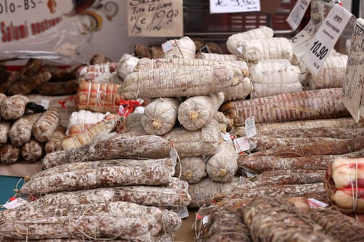 Cremona, Italy - September 7, 2022: Traditional meat products sold at a street stall during the farmers market in Cremona, Lombardy, Italy