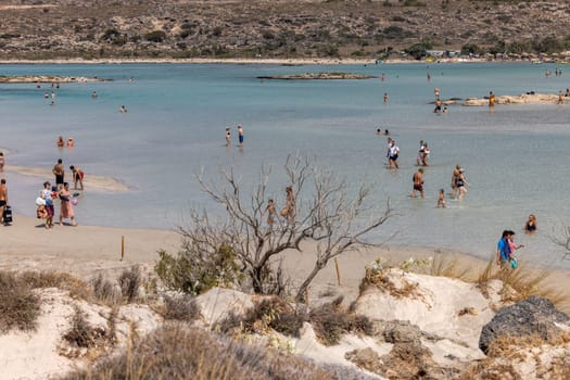 Elafonisi, Crete, Greece - Sept 19, 2021: People relaxing on the famous pink coral beach of Elafonisi on Crete, Mediterannean sea, Greece